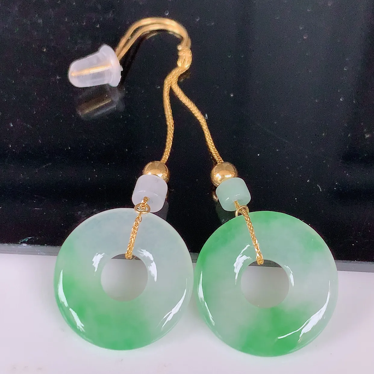 18k金镶嵌冰种飘绿翡翠平安扣耳坠，沁人心脾，耳坠佩戴效果大气出众，尽显气质。种水好，胶感足，颜相当