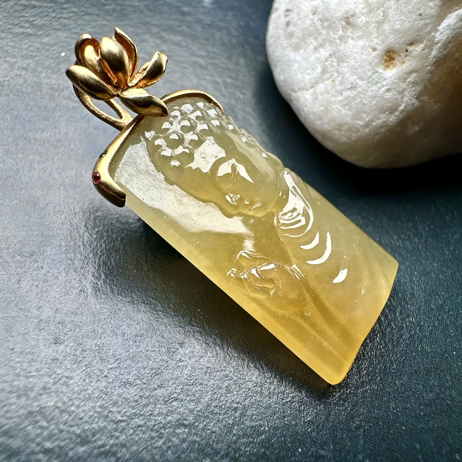 【冰种黄翡宝宝佛首吊坠】侧面像，料子通透闪亮，质地致密，雕刻很精细，18K金钻镶嵌，裸石尺寸26.1