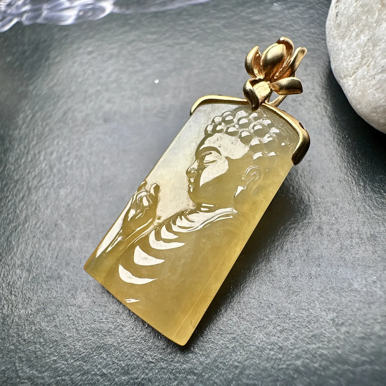 【冰种黄翡宝宝佛首吊坠】侧面像，料子通透闪亮，质地致密，雕刻很精细，18K金钻镶嵌，裸石尺寸26.1*14*4.5毫米