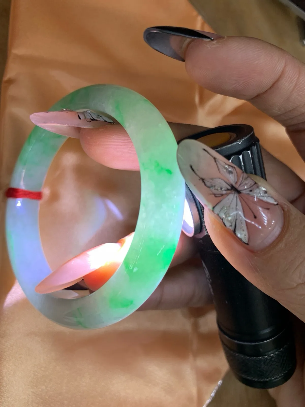 白底青正圈
50-7.8-9.5
打灯棉线，底妆水润细腻，阳绿花点缀腕间风华，干净纯净的底色上，满圈翠色肆意流淌，娇艳欲滴，宛如春日里的繁华盛景