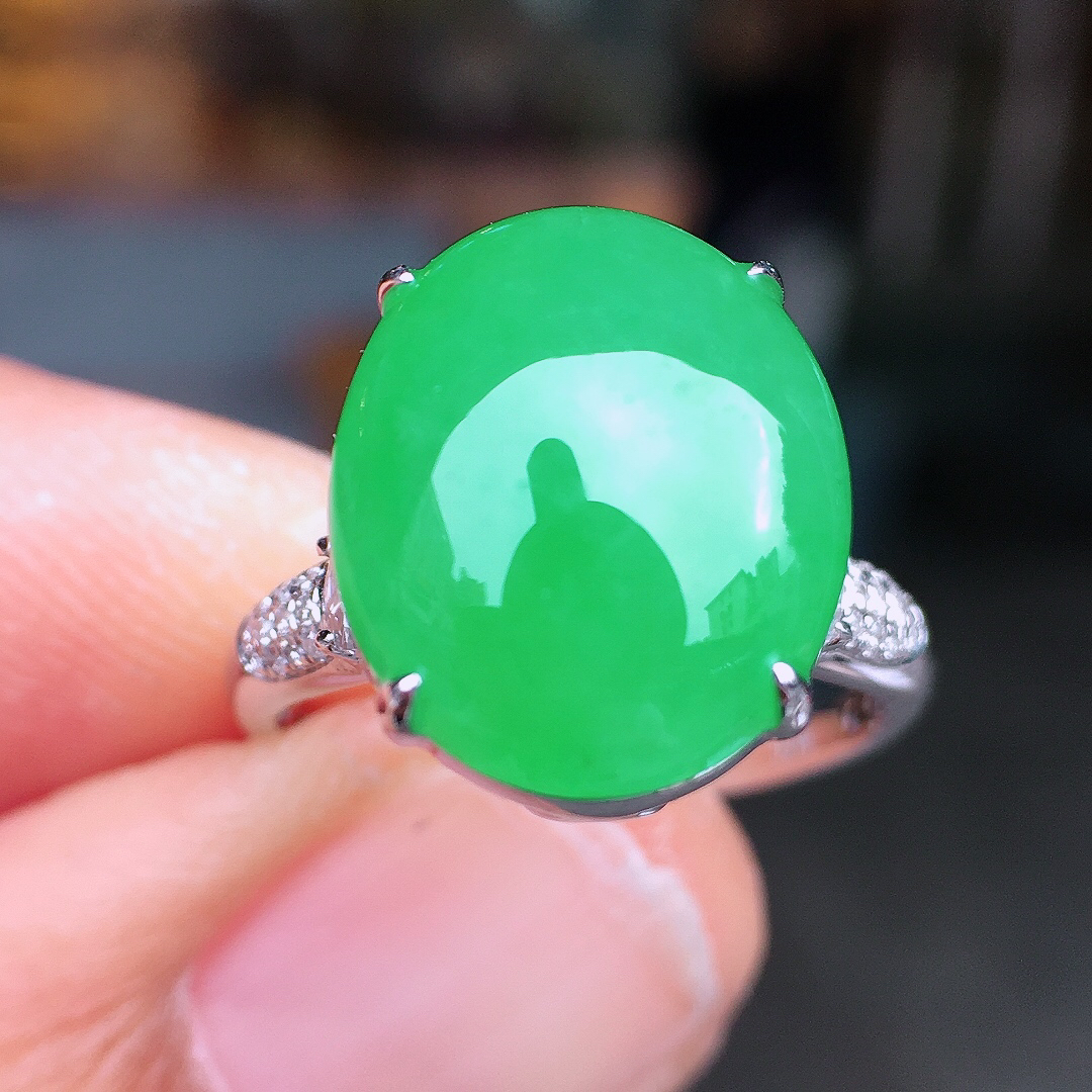 阳绿蛋面戒指，色泽均匀艳丽，玉质细腻，荧光感超
强，饱满圆润，尽显优雅气质，18k
金豪华镶嵌