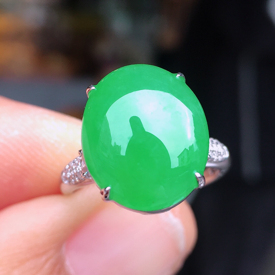 阳绿蛋面戒指，色泽均匀艳丽，玉质细腻，荧光感超
强，饱满圆润，尽显优雅气质，18k
金豪华镶嵌