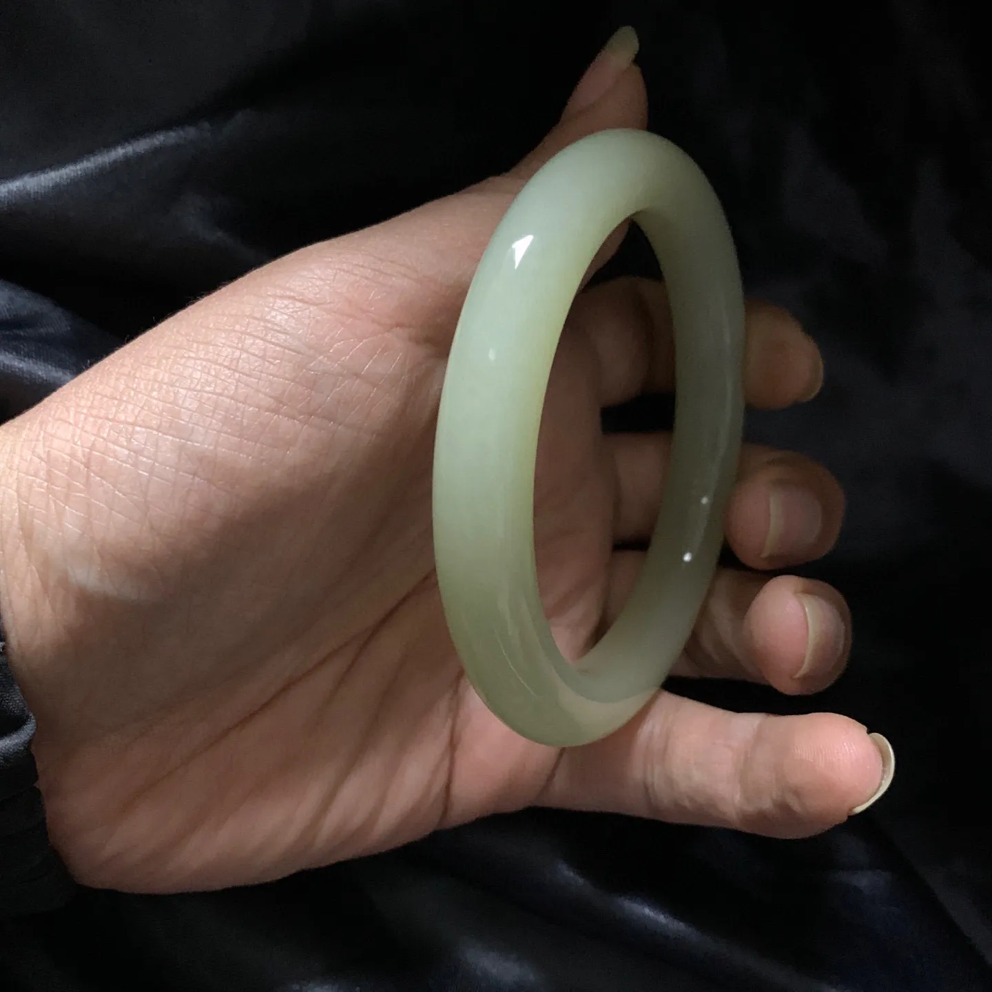 63圈口和田玉清水色手镯【挽间柔情】，和田玉63圈口手镯，镯型古朴典雅。在诗情画意的雨巷相遇，你是我腕间的一抹风情，有你眸有深情.清风荡漾湖间静水，我愿俯身低眉，在烟波涟漪处寻