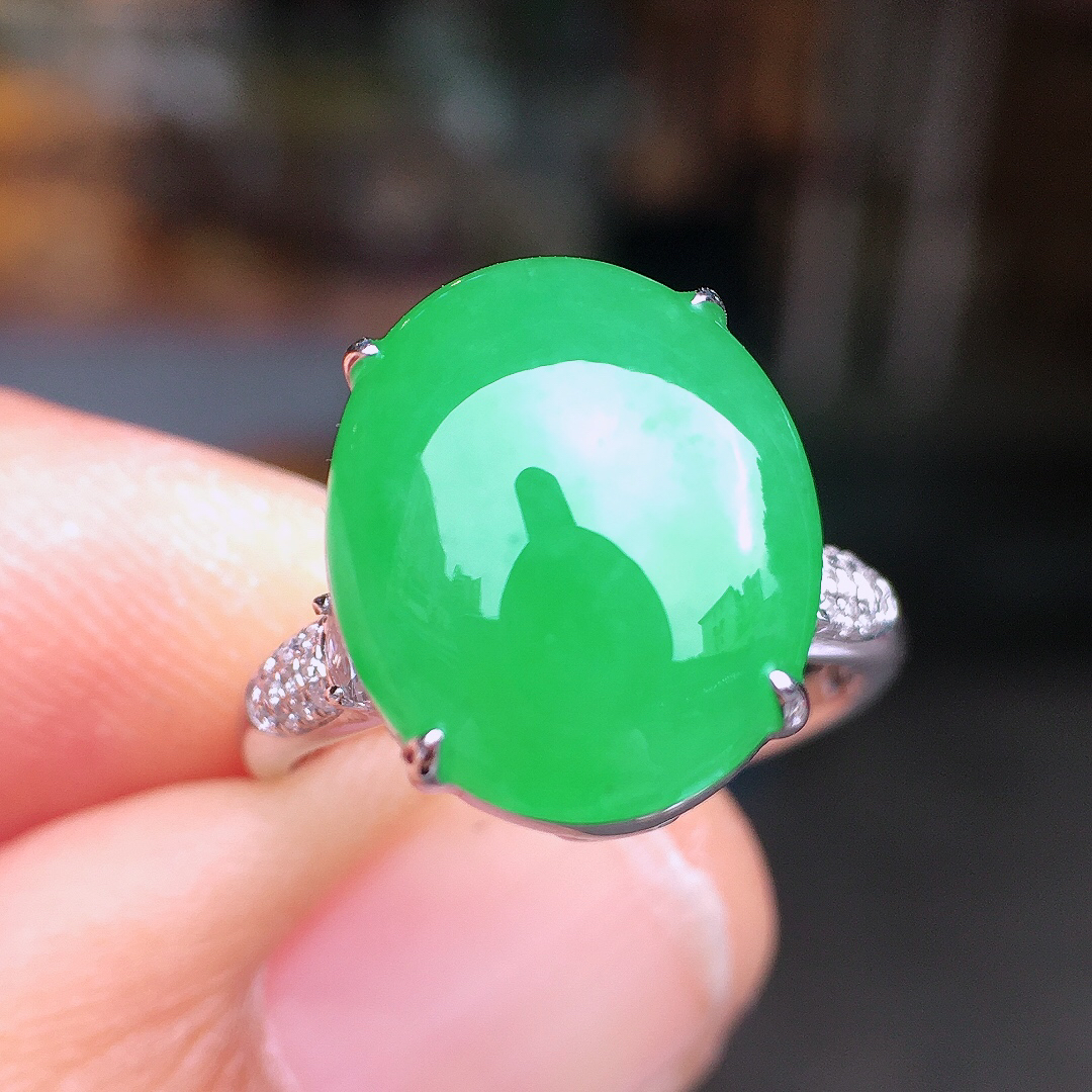 阳绿蛋面戒指，色泽均匀艳丽，玉质细腻，荧光感超
强，饱满圆润，尽显优雅气质，18k
金豪华镶嵌