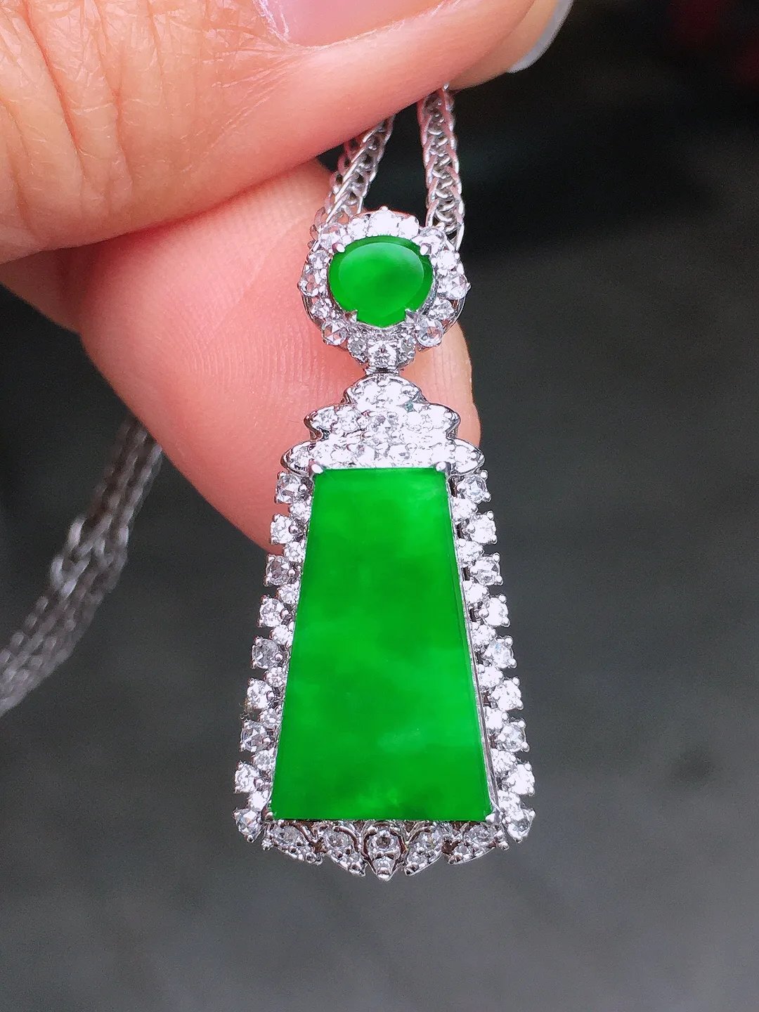 阳绿无事牌吊坠，色泽均匀艳丽，玉质细腻，荧光感超
强，饱满圆润，尽显优雅气质，18k
金豪华镶嵌