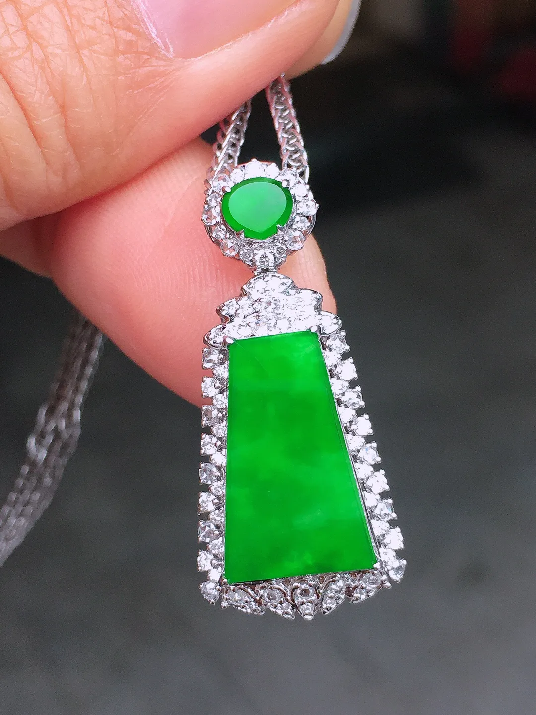 阳绿无事牌吊坠，色泽均匀艳丽，玉质细腻，荧光感超
强，饱满圆润，尽显优雅气质，18k
金豪华镶嵌