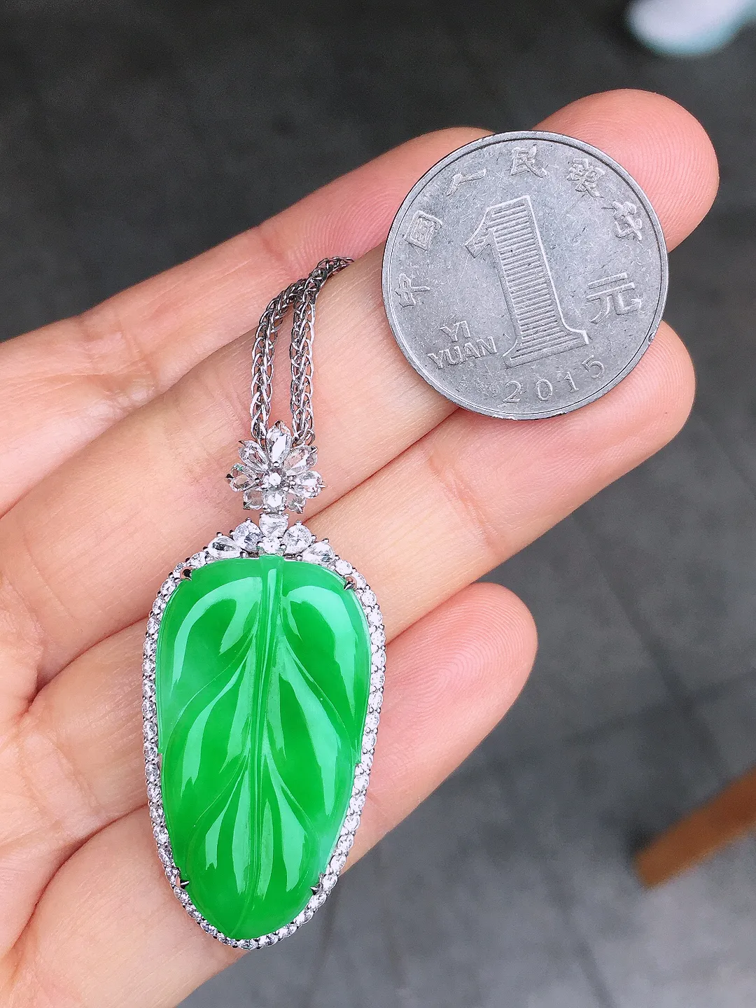 阳绿玉叶吊坠，色泽均匀艳丽，玉质细腻，荧光感超
强，饱满圆润，尽显优雅气质，18k
金豪华镶嵌