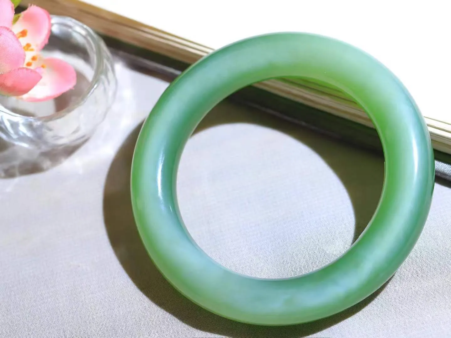 （碧色荡漾.手镯）

典藏级臻品️和田玉碧玉猫眼圆条手镯，灼灼其华想像靓妆淡伫 ，腕间绿意跳脱冰壶莹，坐间静对，姑射仙姿潇洒处，艳冶最奇料子油润滋腻镯型饱满，手感上佳。重79.2克   内径56mm尺寸12-12.3mm  24102213T