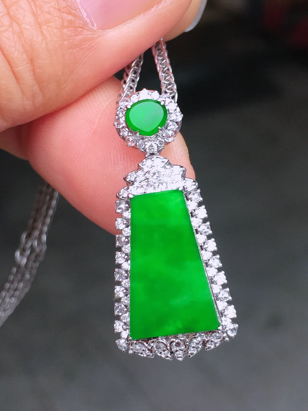 阳绿无事牌吊坠，色泽均匀艳丽，玉质细腻，荧光感超
强，饱满圆润，尽显优雅气质，18k
金豪华镶嵌