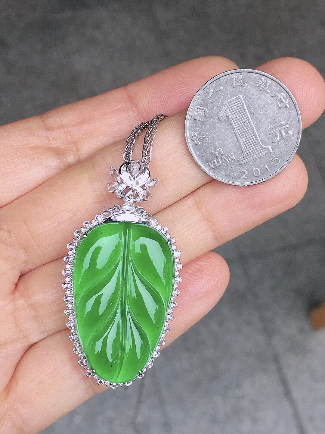 阳绿玉叶吊坠，色泽均匀艳丽，玉质细腻，荧光感超
强，饱满圆润，尽显优雅气质，18k
金豪华镶嵌