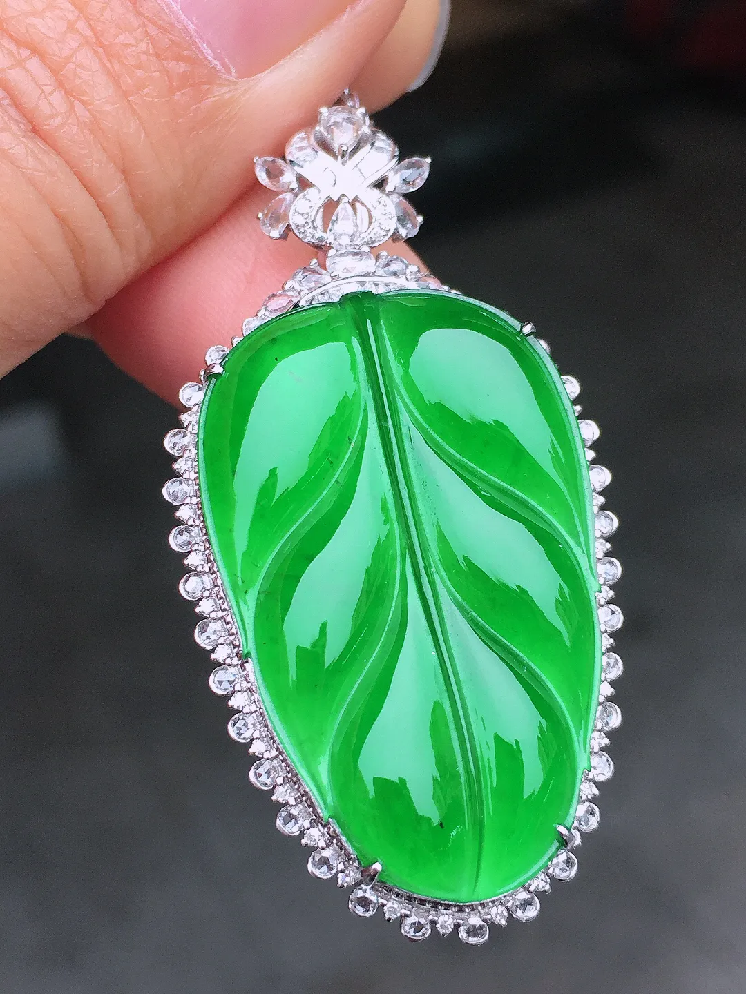 阳绿玉叶吊坠，色泽均匀艳丽，玉质细腻，荧光感超
强，饱满圆润，尽显优雅气质，18k
金豪华镶嵌