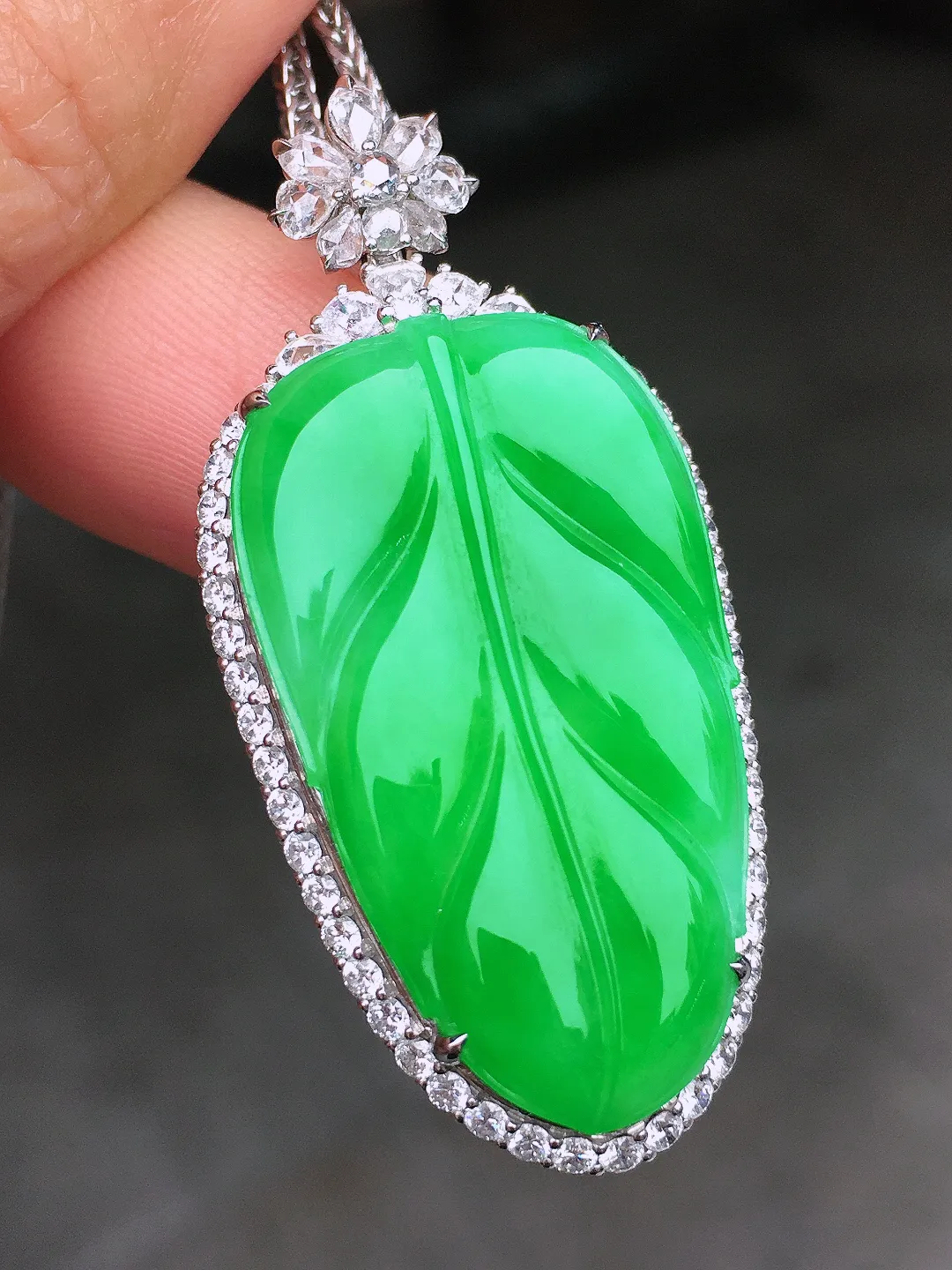 阳绿玉叶吊坠，色泽均匀艳丽，玉质细腻，荧光感超
强，饱满圆润，尽显优雅气质，18k
金豪华镶嵌