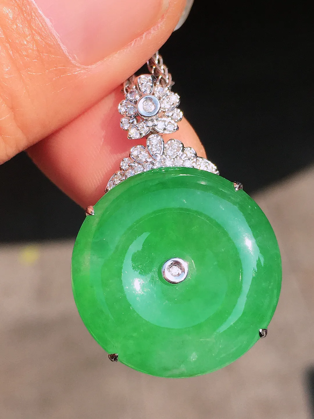 阳绿平安扣吊坠，色泽均匀艳丽，玉质细腻，荧光感超
强，饱满圆润，尽显优雅气质，18k
金豪华镶嵌