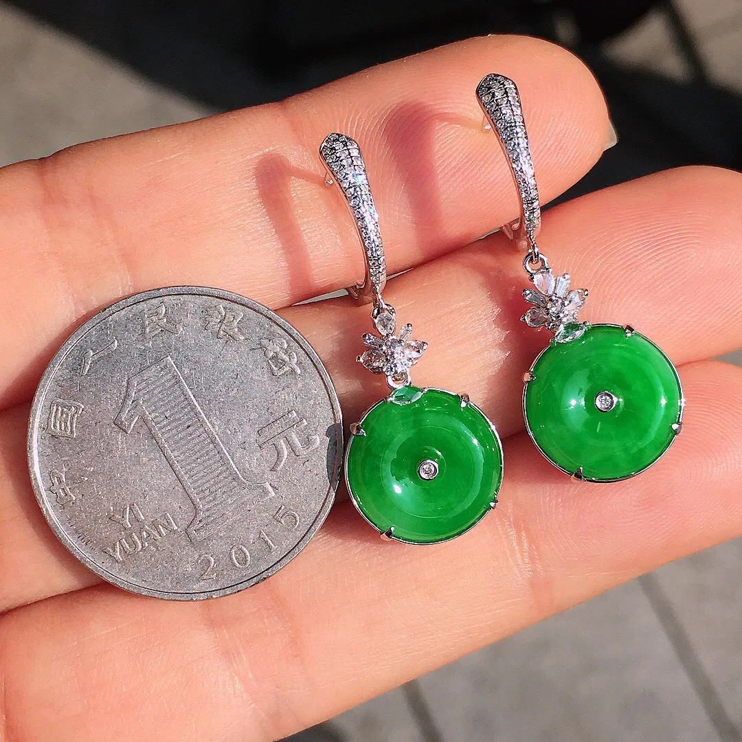 阳绿平安扣耳坠，色泽均匀艳丽，玉质细腻，荧光感超
强，饱满圆润，尽显优雅气质，18k
金豪华镶嵌