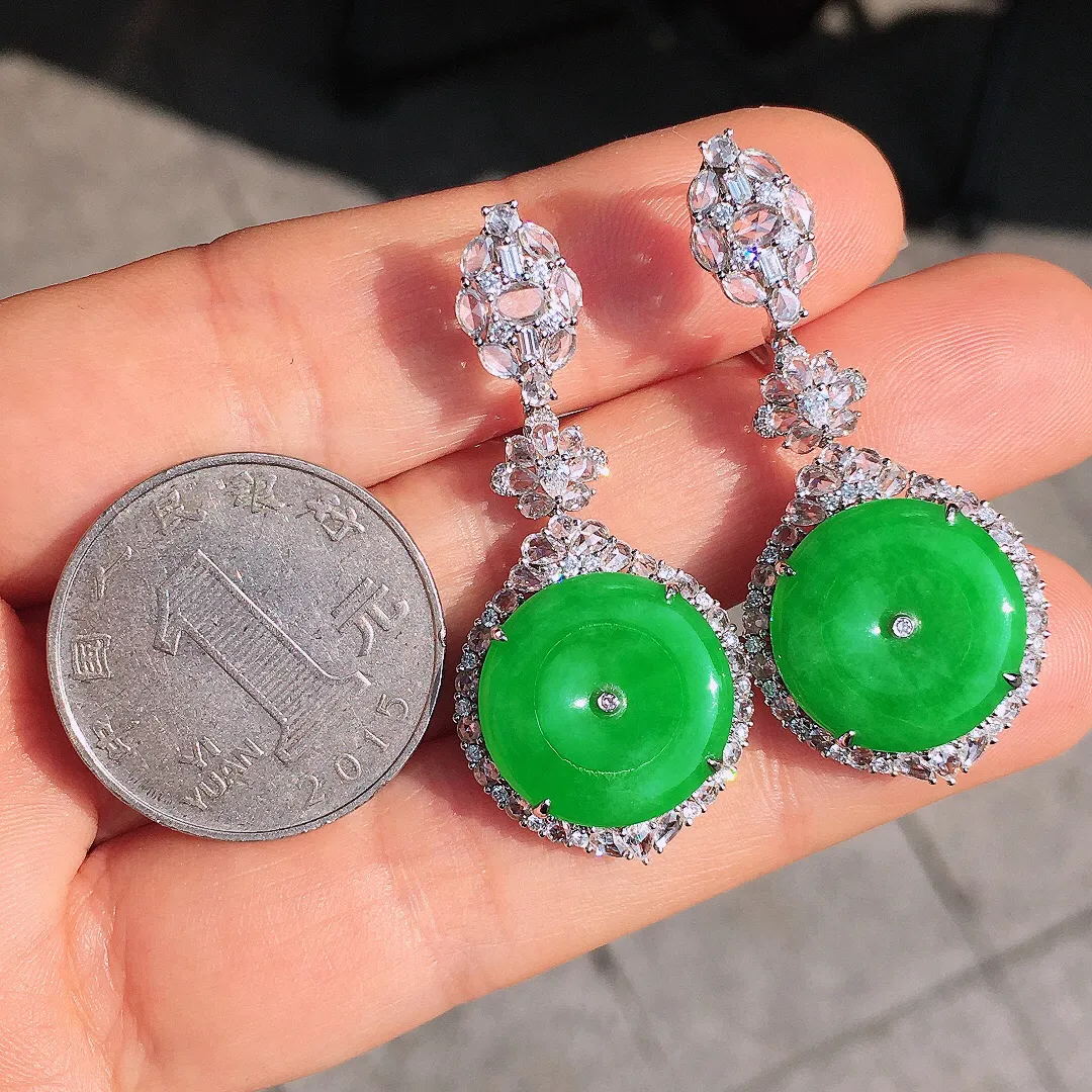 阳绿平安扣耳坠，色泽均匀艳丽，玉质细腻，荧光感超
强，饱满圆润，尽显优雅气质，18k
金豪华镶嵌