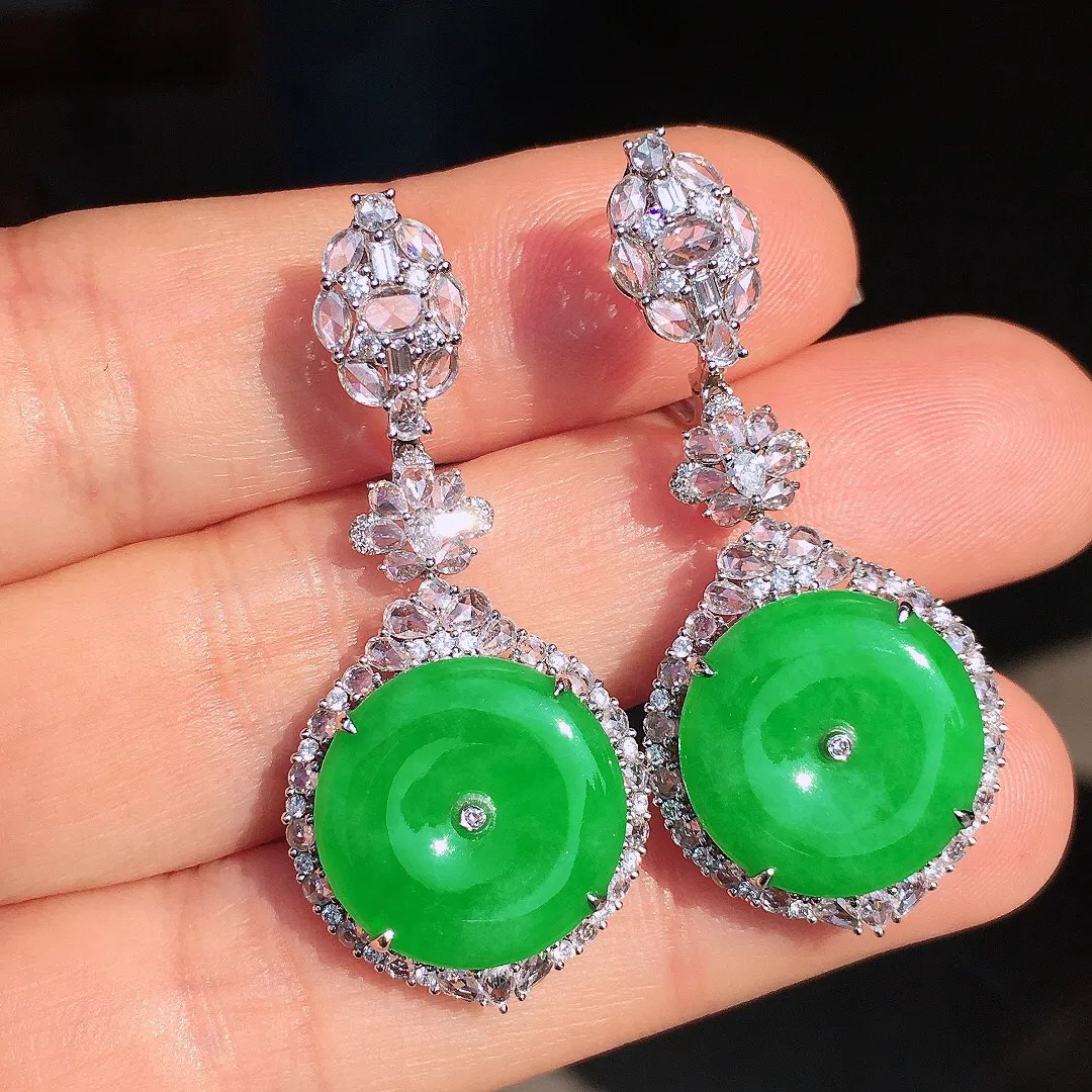 阳绿平安扣耳坠，色泽均匀艳丽，玉质细腻，荧光感超
强，饱满圆润，尽显优雅气质，18k
金豪华镶嵌