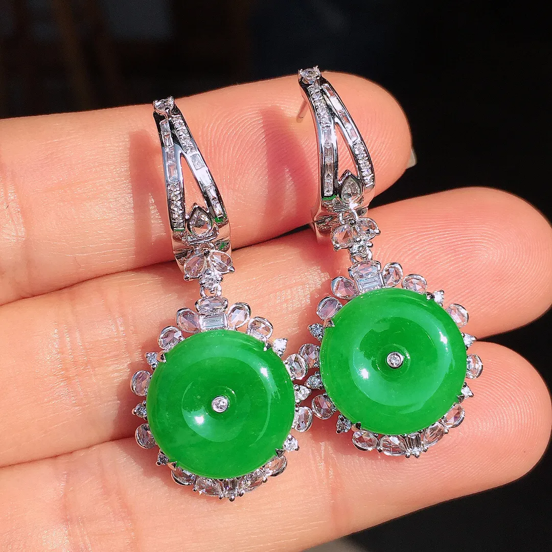 阳绿平安扣耳坠，色泽均匀艳丽，玉质细腻，荧光感超
强，饱满圆润，尽显优雅气质，18k
金豪华镶嵌