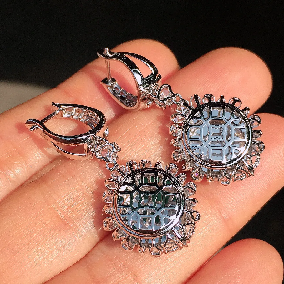 阳绿平安扣耳坠，色泽均匀艳丽，玉质细腻，荧光感超
强，饱满圆润，尽显优雅气质，18k
金豪华镶嵌