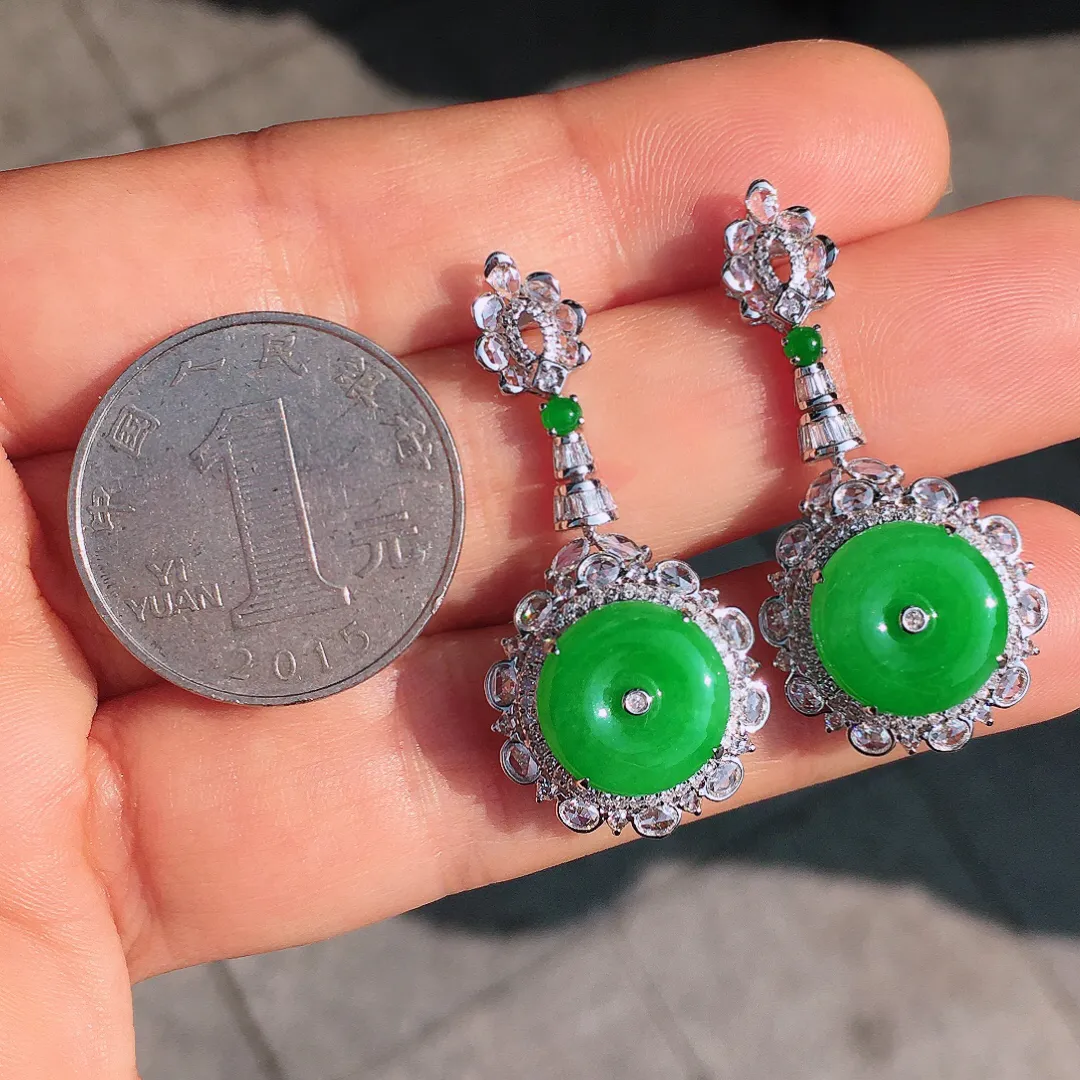 阳绿平安扣耳坠，色泽均匀艳丽，玉质细腻，荧光感超
强，饱满圆润，尽显优雅气质，18k
金豪华镶嵌