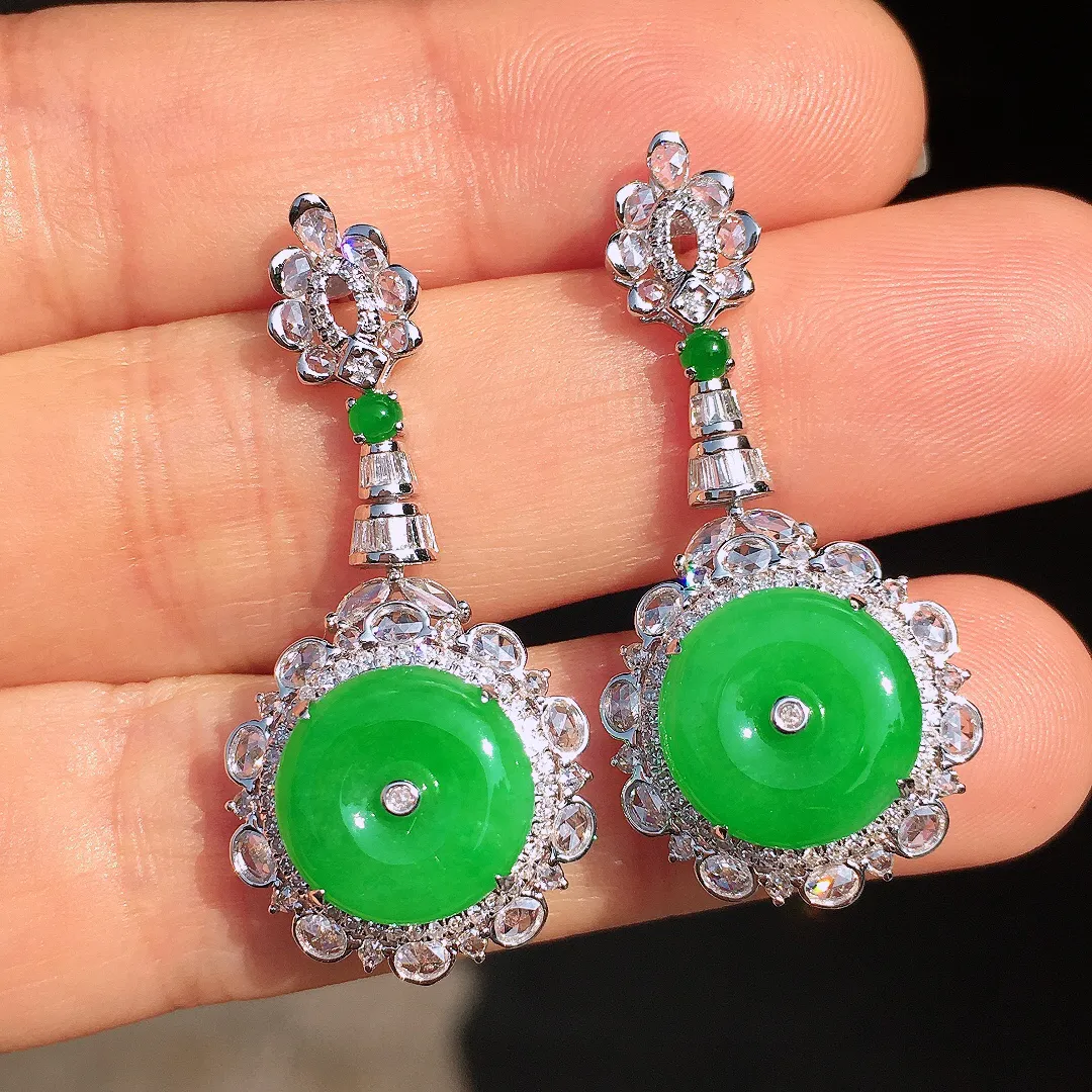 阳绿平安扣耳坠，色泽均匀艳丽，玉质细腻，荧光感超
强，饱满圆润，尽显优雅气质，18k
金豪华镶嵌