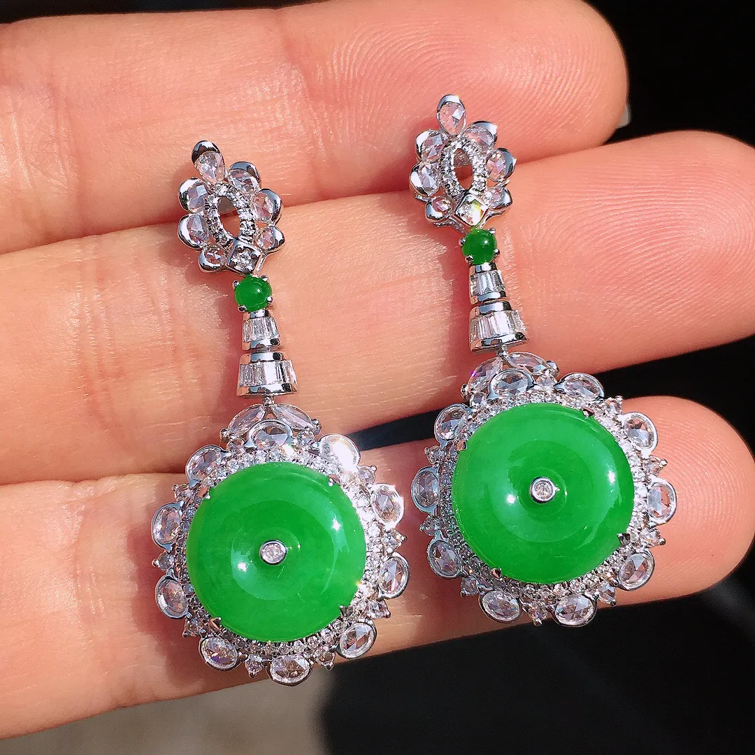 阳绿平安扣耳坠，色泽均匀艳丽，玉质细腻，荧光感超
强，饱满圆润，尽显优雅气质，18k
金豪华镶嵌