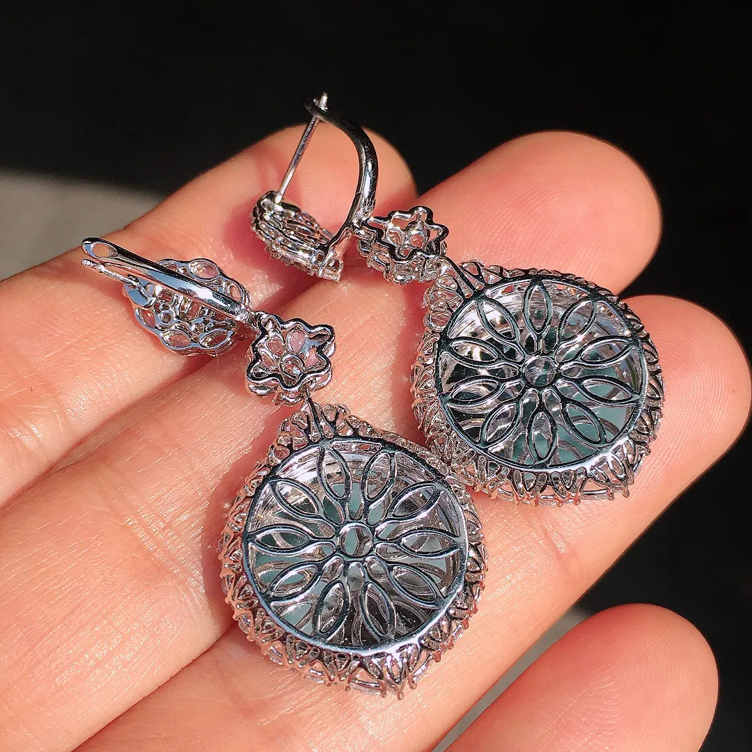 阳绿平安扣耳坠，色泽均匀艳丽，玉质细腻，荧光感超
强，饱满圆润，尽显优雅气质，18k
金豪华镶嵌