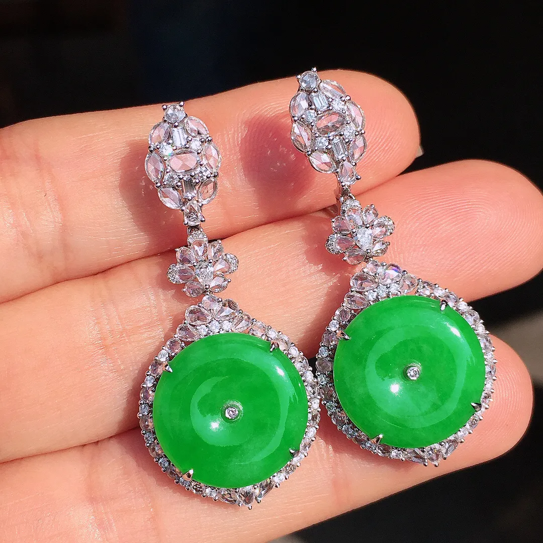 阳绿平安扣耳坠，色泽均匀艳丽，玉质细腻，荧光感超
强，饱满圆润，尽显优雅气质，18k
金豪华镶嵌