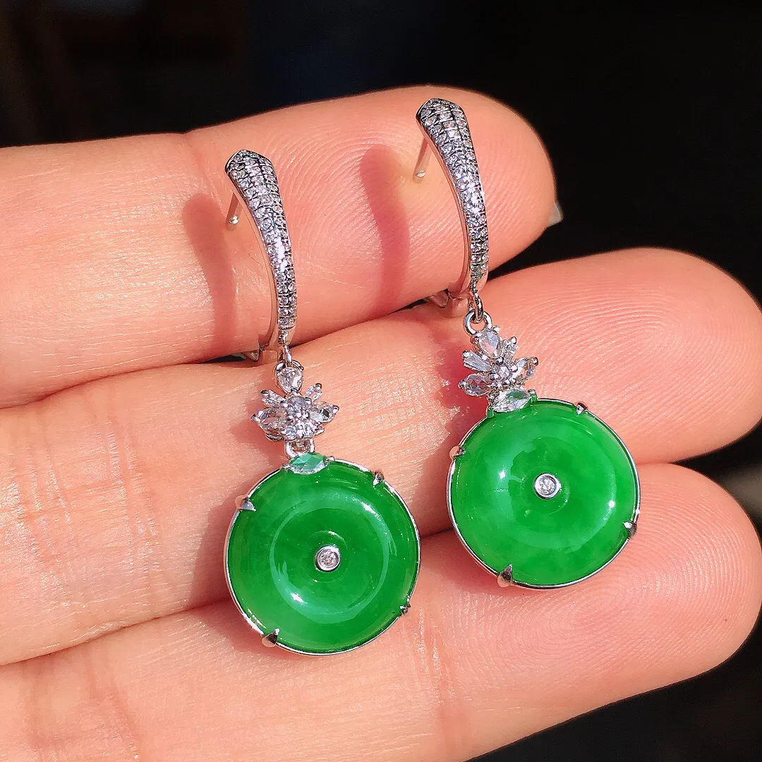 阳绿平安扣耳坠，色泽均匀艳丽，玉质细腻，荧光感超
强，饱满圆润，尽显优雅气质，18k
金豪华镶嵌