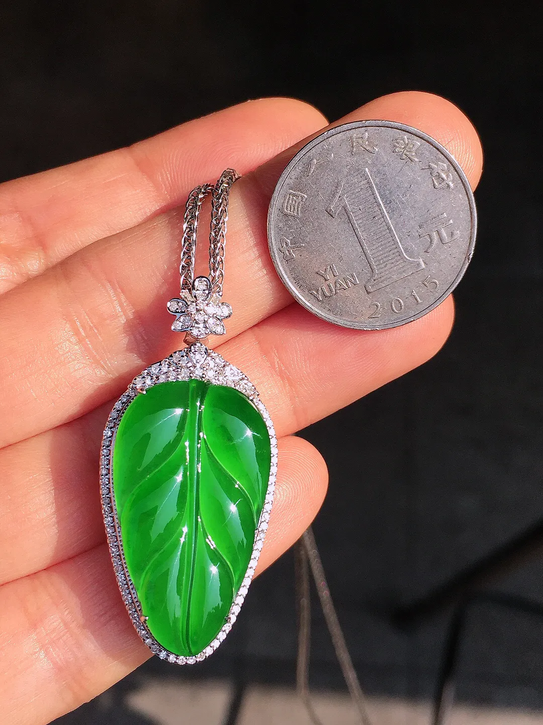 阳绿玉叶吊坠，色泽均匀艳丽，玉质细腻，荧光感超
强，饱满圆润，尽显优雅气质，18k
金豪华镶嵌