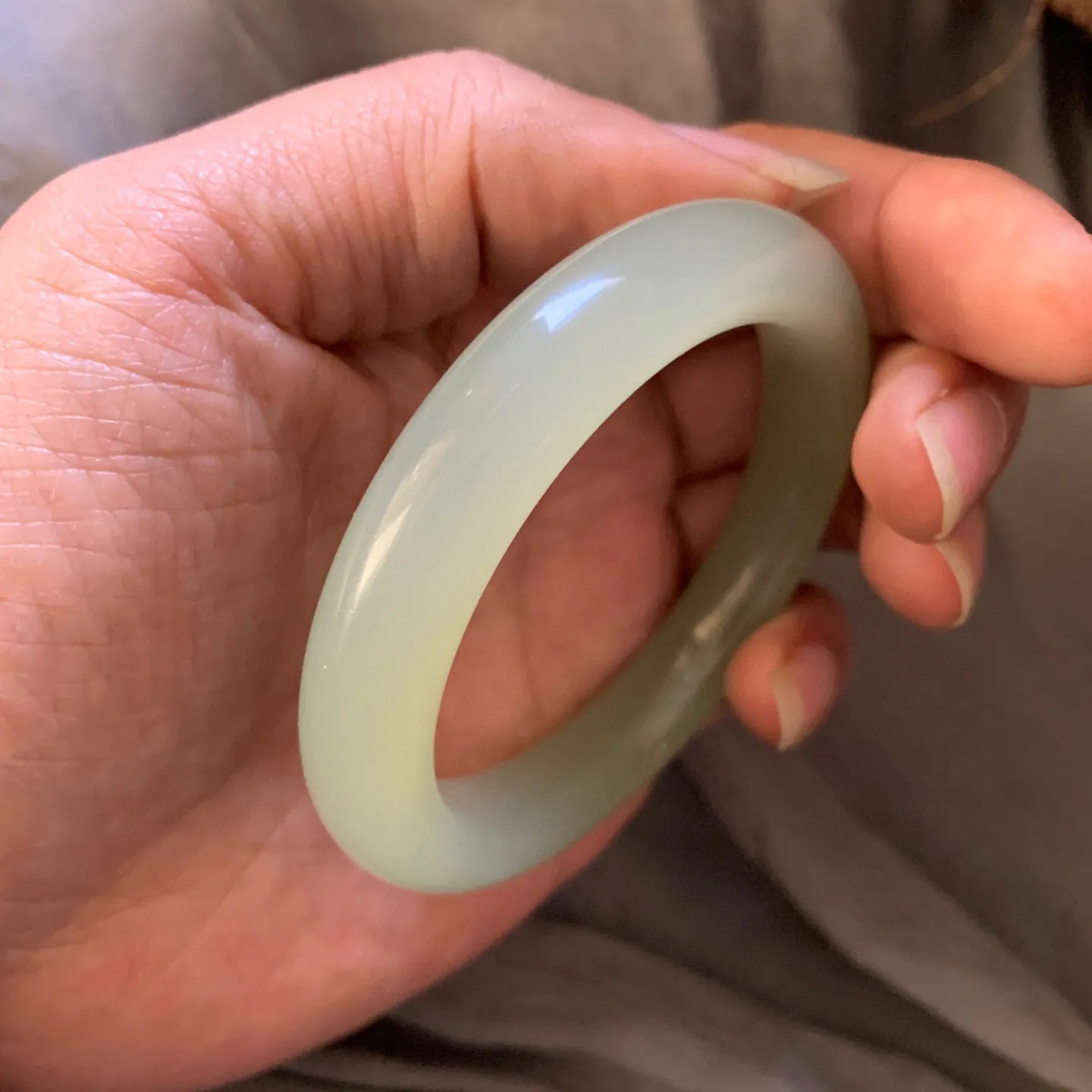 55.3圈口和田玉且清水色猫眼手镯【挽间柔情】，冰透十足，和田玉55圈口晴水猫眼手镯，镯型古朴典雅。在诗情画意的雨巷相遇，你是我腕间的一抹风情，有你眸有深情.清风荡漾湖间静水，我愿俯身低眉，在烟波涟漪处寻