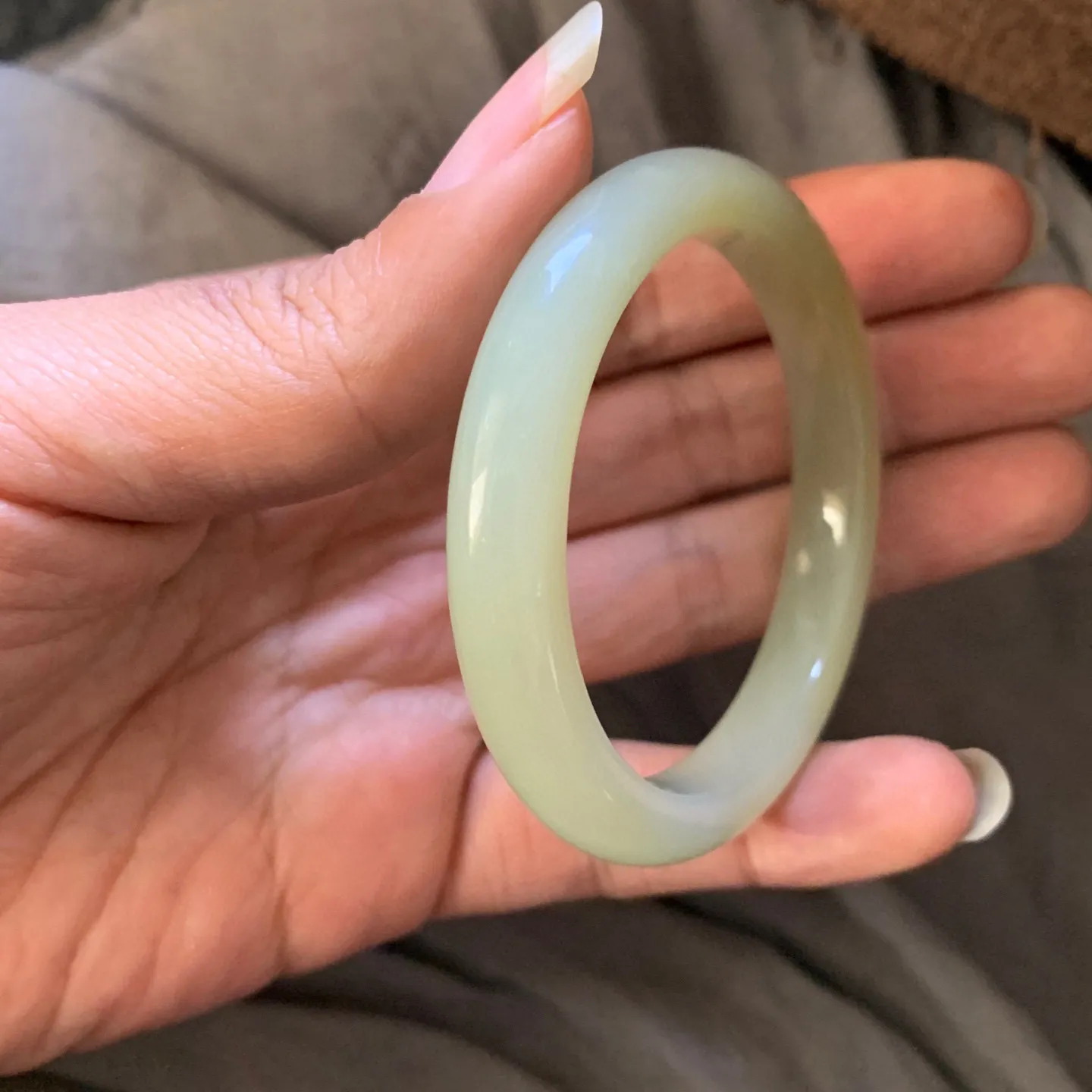 53圈口和田玉且末糖料手镯【挽间柔情】，和田玉53圈口手镯，镯型古朴典雅。在诗情画意的雨巷相遇，你是我腕间的一抹风情，有你眸有深情.清风荡漾湖间静水，我愿俯身低眉，在烟波涟漪处寻