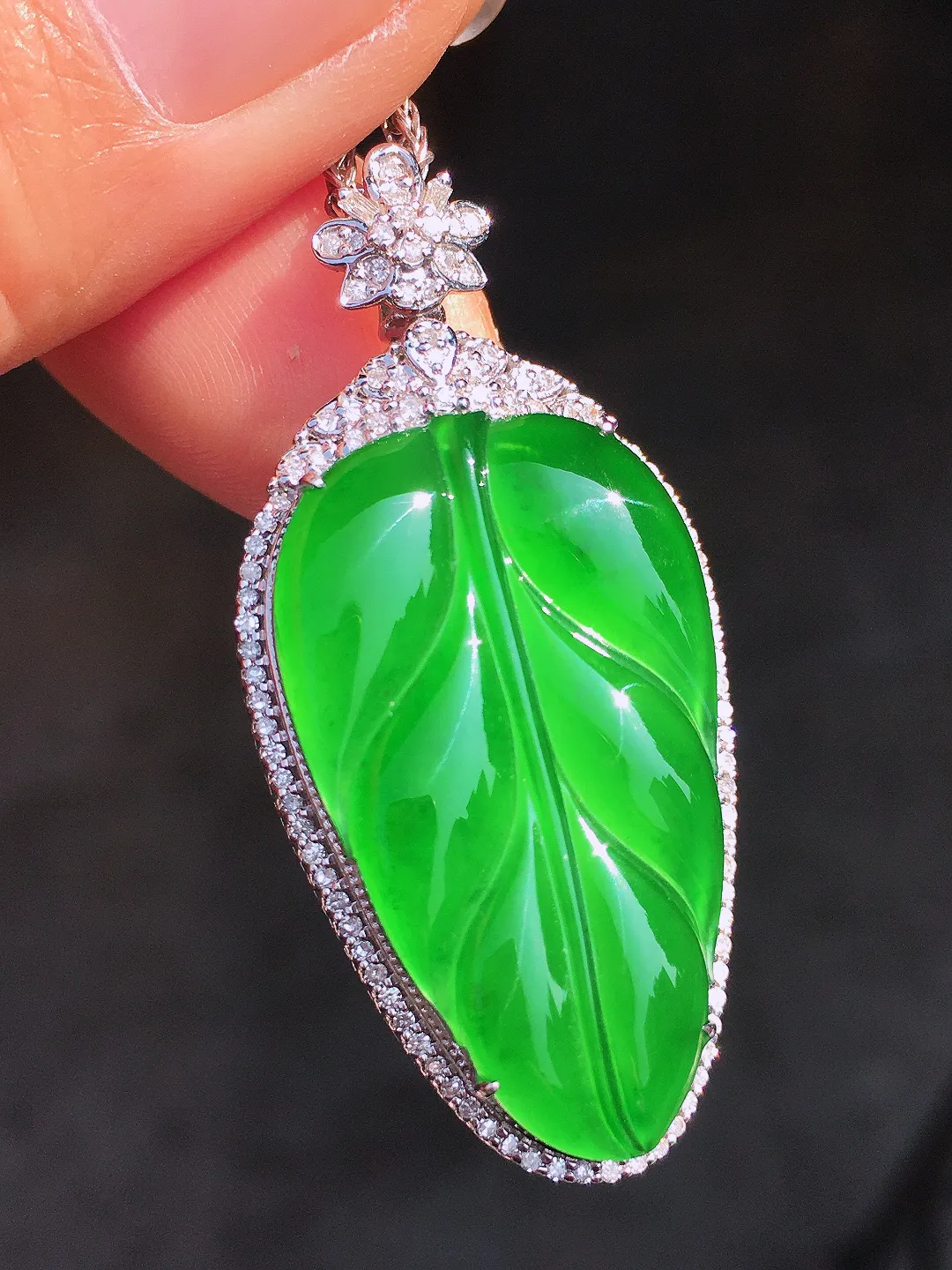 阳绿玉叶吊坠，色泽均匀艳丽，玉质细腻，荧光感超
强，饱满圆润，尽显优雅气质，18k
金豪华镶嵌