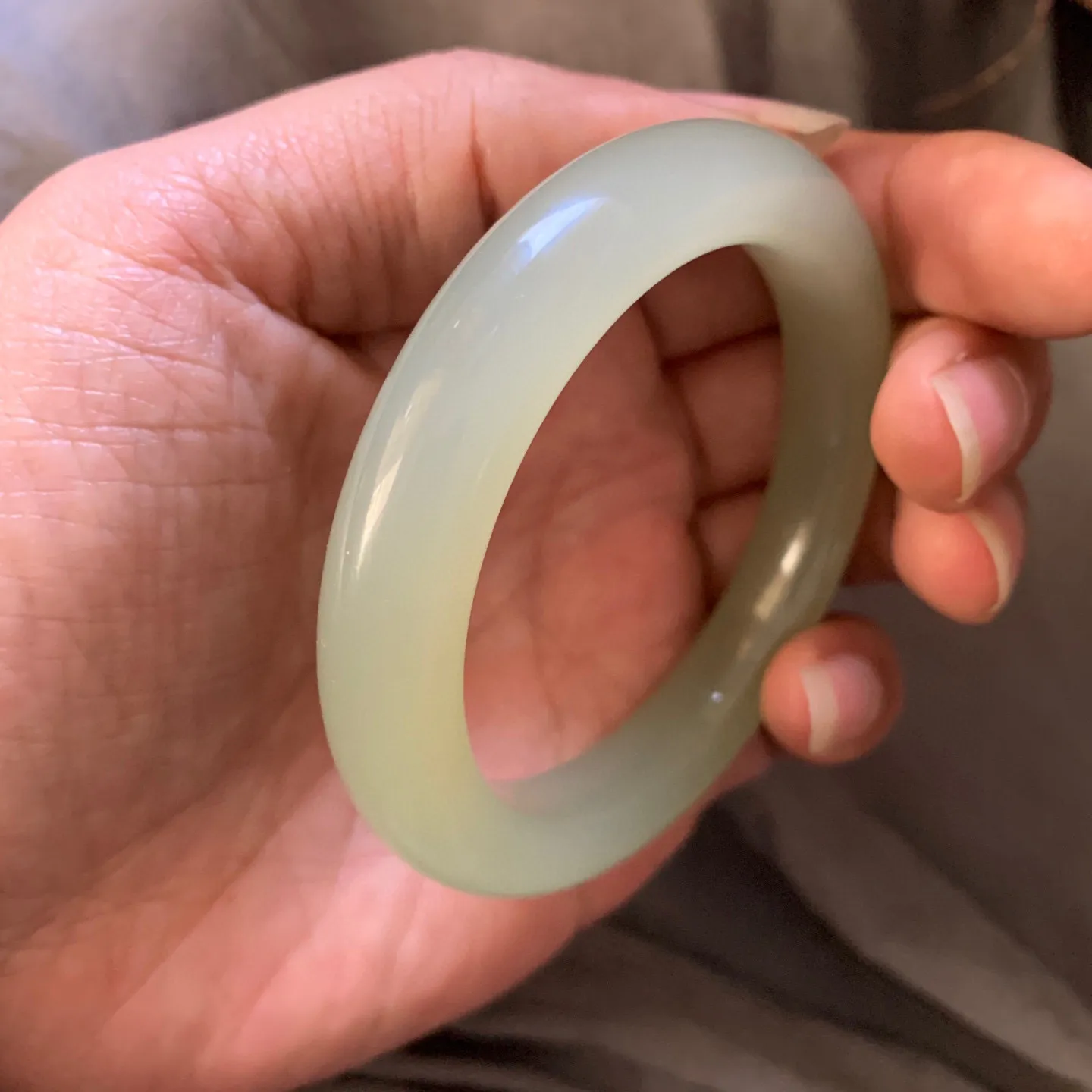 55.3圈口和田玉且清水色猫眼手镯【挽间柔情】，冰透十足，和田玉55圈口晴水猫眼手镯，镯型古朴典雅。在诗情画意的雨巷相遇，你是我腕间的一抹风情，有你眸有深情.清风荡漾湖间静水，我愿俯身低眉，在烟波涟漪处寻