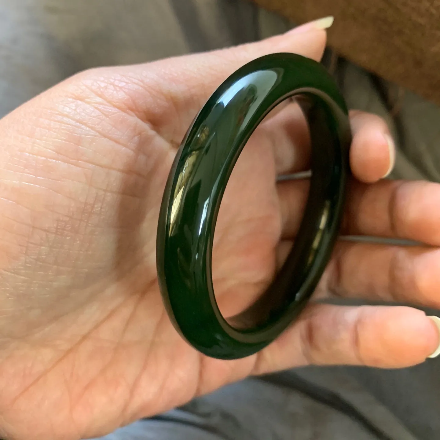 57.5圈口新疆和田玉碧玉菠菜绿手镯【挽间柔情】，和田玉57.5圈口碧玉手镯，镯型古朴典雅。在诗情画意的雨巷相遇，你是我腕间的一抹风情，有你眸有深情.清风荡漾湖间静水，我愿俯身低眉，在烟波涟漪处寻