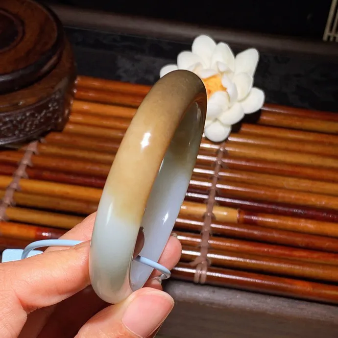 56圈口 新疆和田玉且末糖手镯 且末糖半山半水手镯 56圈口条宽 11.5厚8重53.5克。玉质细腻油润。手推出油。佩戴高端典雅。lt260125