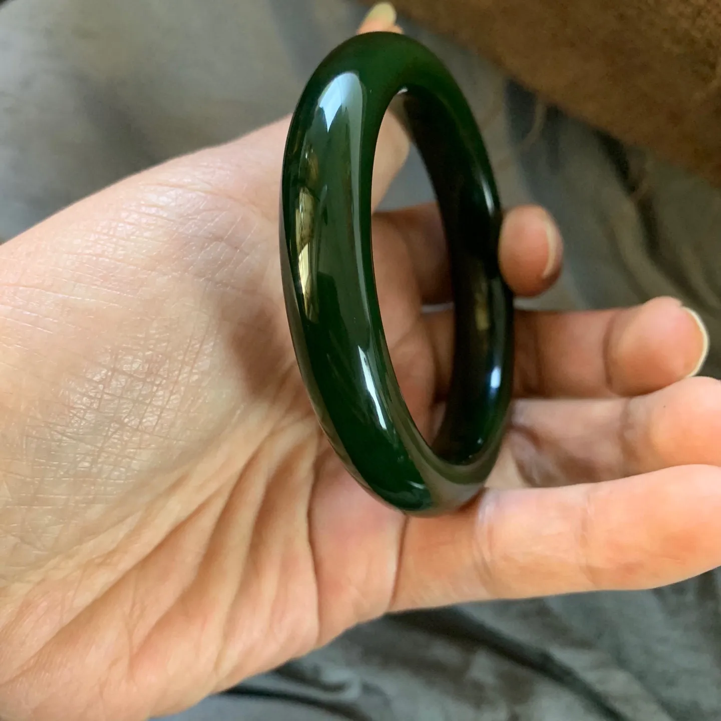 57.5圈口新疆和田玉碧玉菠菜绿手镯【挽间柔情】，和田玉57.5圈口碧玉手镯，镯型古朴典雅。在诗情画意的雨巷相遇，你是我腕间的一抹风情，有你眸有深情.清风荡漾湖间静水，我愿俯身低眉，在烟波涟漪处寻