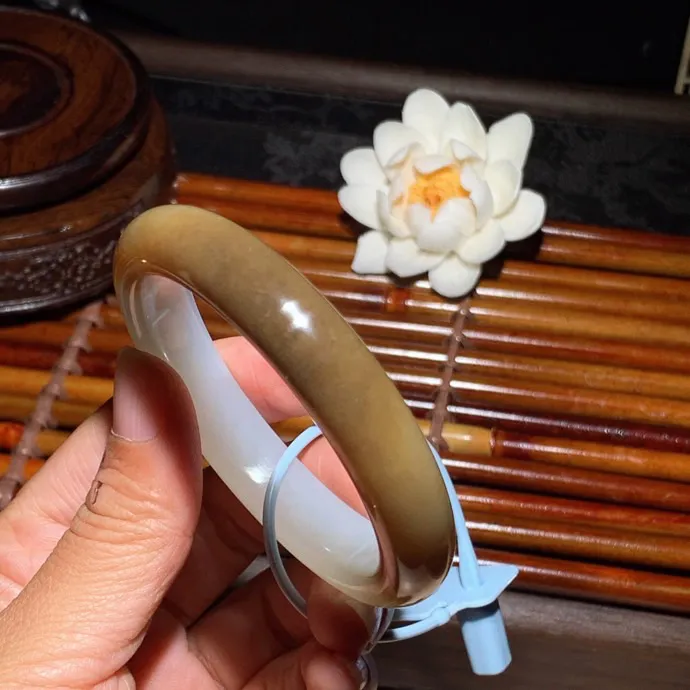 56圈口 新疆和田玉且末糖手镯 且末糖半山半水手镯 56圈口条宽 11.5厚8重53.5克。玉质细腻油润。手推出油。佩戴高端典雅。lt260125