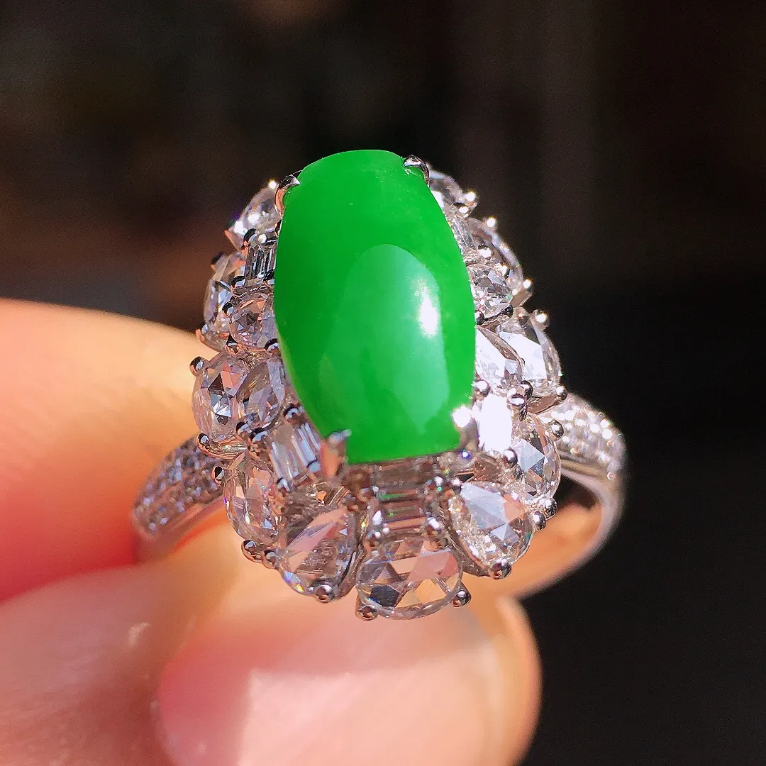 阳绿马鞍戒指，色泽均匀艳丽，玉质细腻，荧光感超
强，饱满圆润，尽显优雅气质，18k
金豪华镶嵌