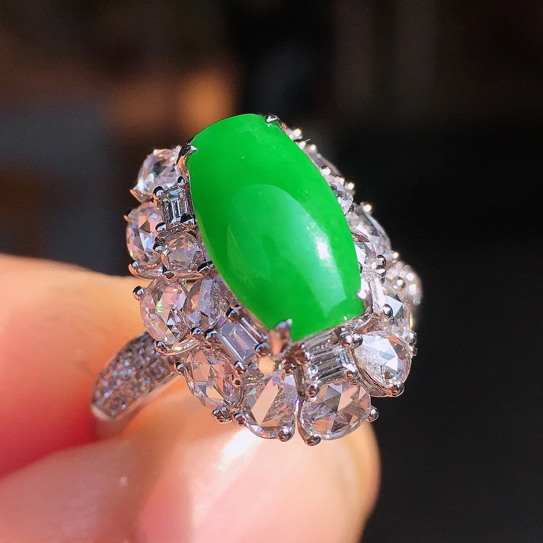 阳绿马鞍戒指，色泽均匀艳丽，玉质细腻，荧光感超
强，饱满圆润，尽显优雅气质，18k
金豪华镶嵌