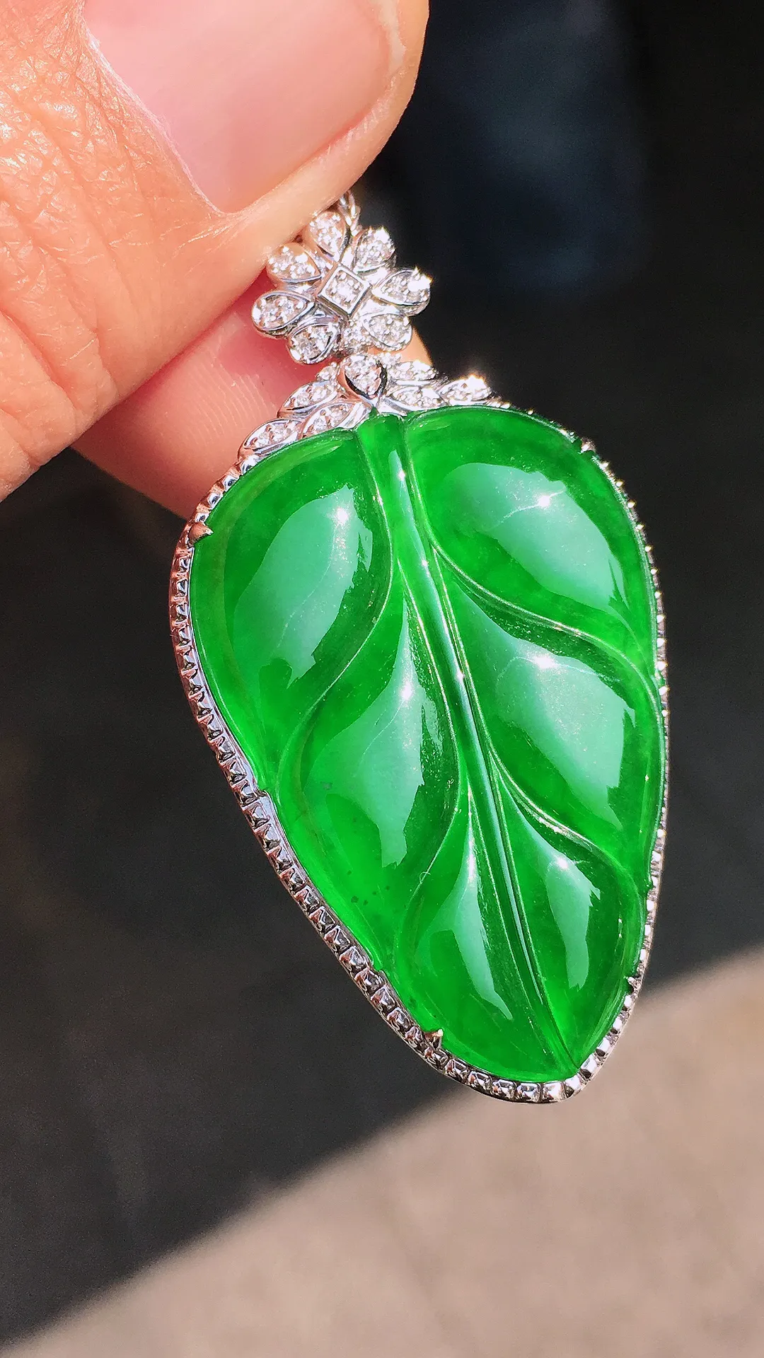 阳绿玉叶吊坠，色泽均匀艳丽，玉质细腻，荧光感超
强，饱满圆润，尽显优雅气质，18k
金豪华镶嵌