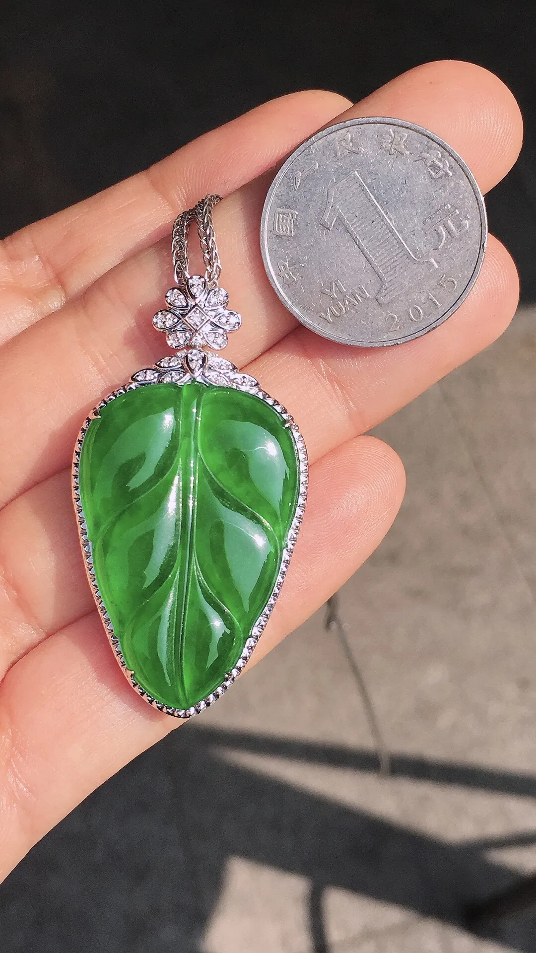 阳绿玉叶吊坠，色泽均匀艳丽，玉质细腻，荧光感超
强，饱满圆润，尽显优雅气质，18k
金豪华镶嵌