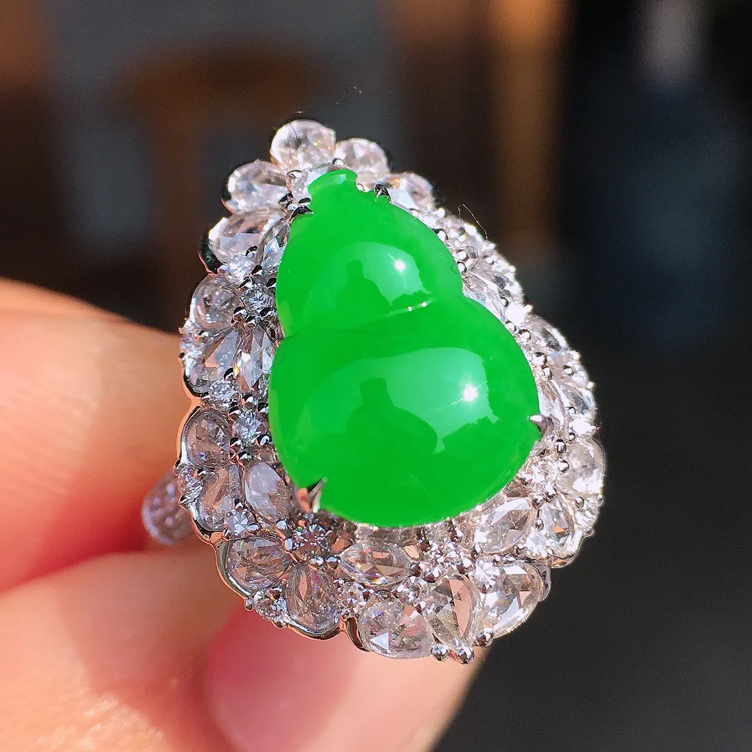 阳绿葫芦戒指，色泽均匀艳丽，玉质细腻，荧光感超
强，饱满圆润，尽显优雅气质，18k
金豪华镶嵌