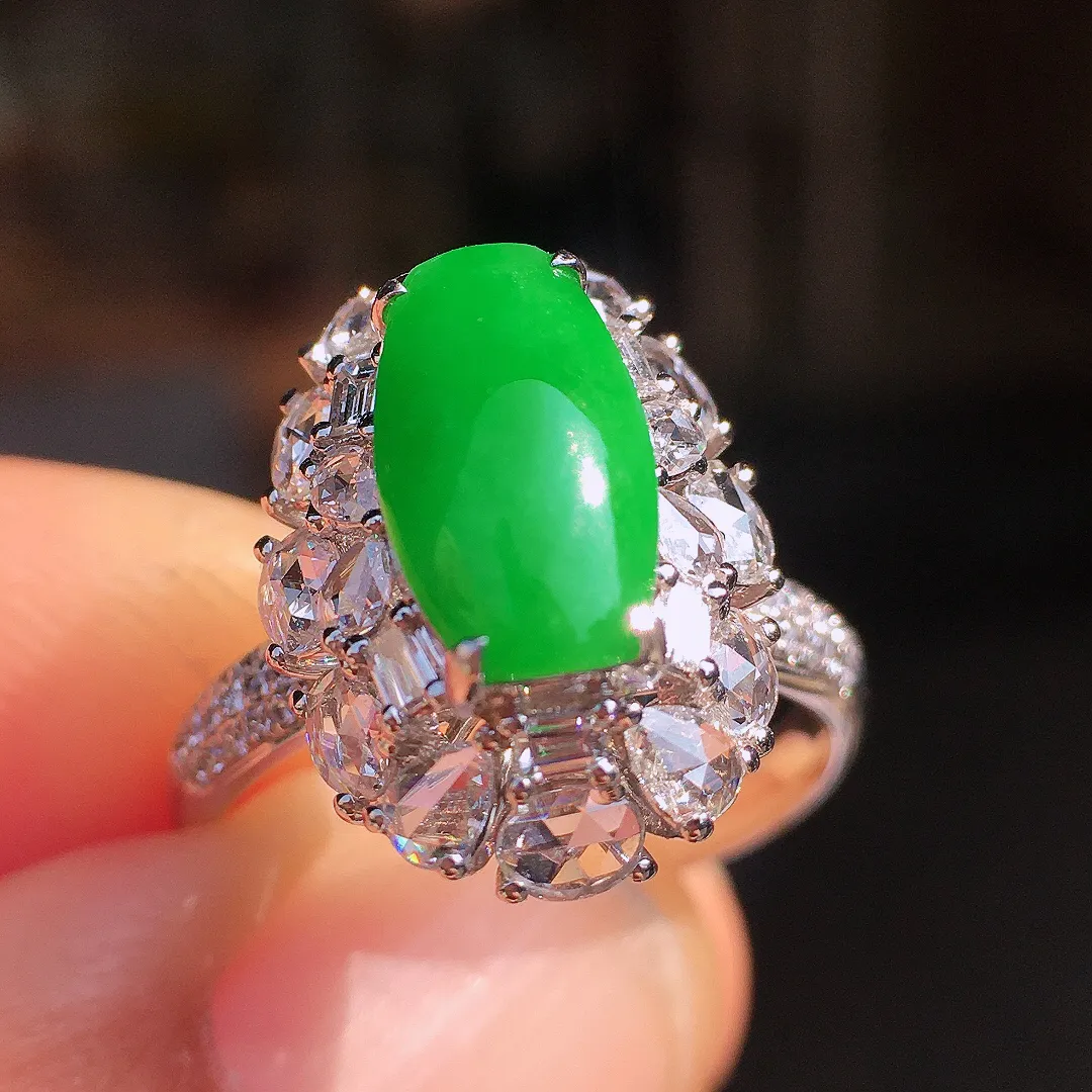 阳绿马鞍戒指，色泽均匀艳丽，玉质细腻，荧光感超
强，饱满圆润，尽显优雅气质，18k
金豪华镶嵌