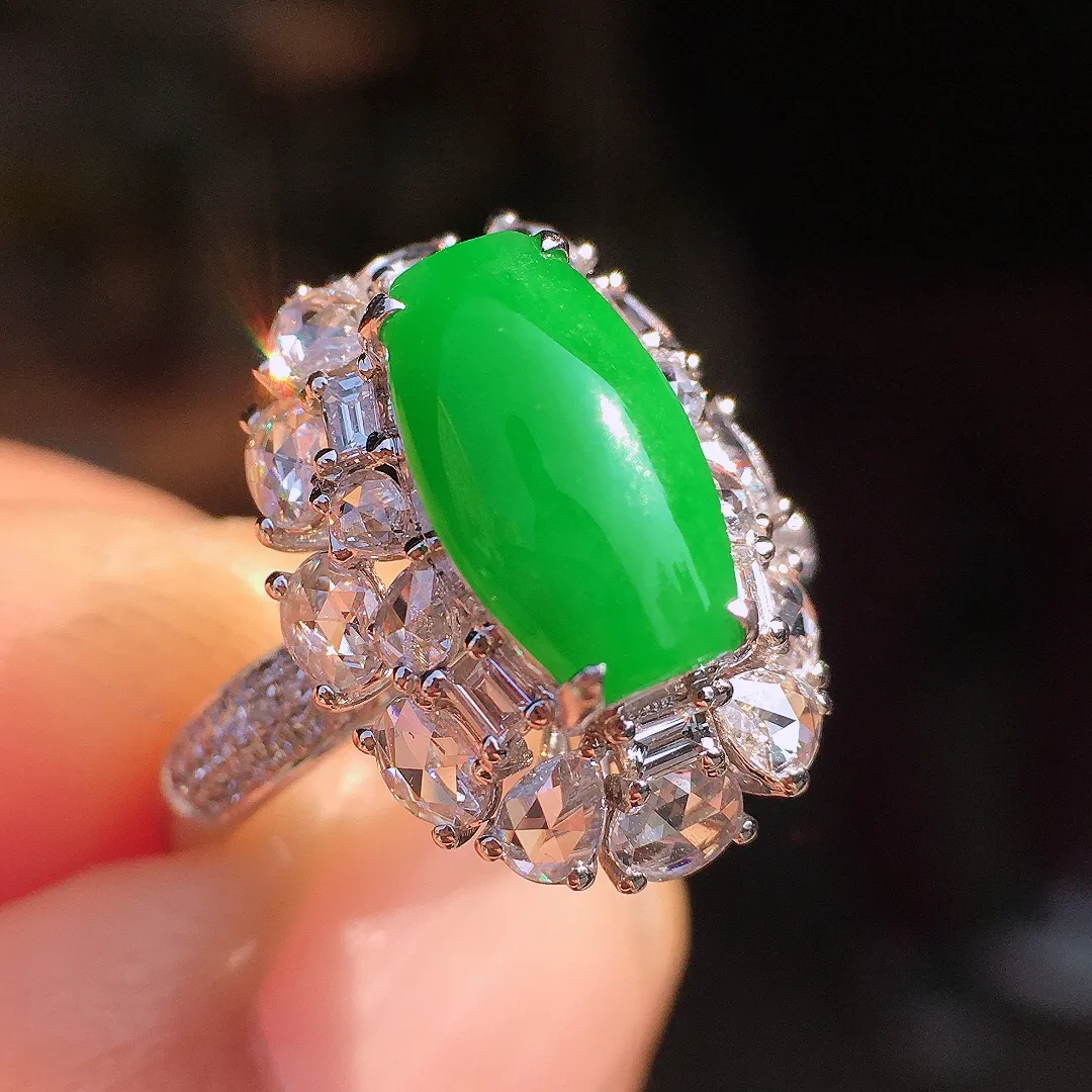 阳绿马鞍戒指，色泽均匀艳丽，玉质细腻，荧光感超
强，饱满圆润，尽显优雅气质，18k
金豪华镶嵌