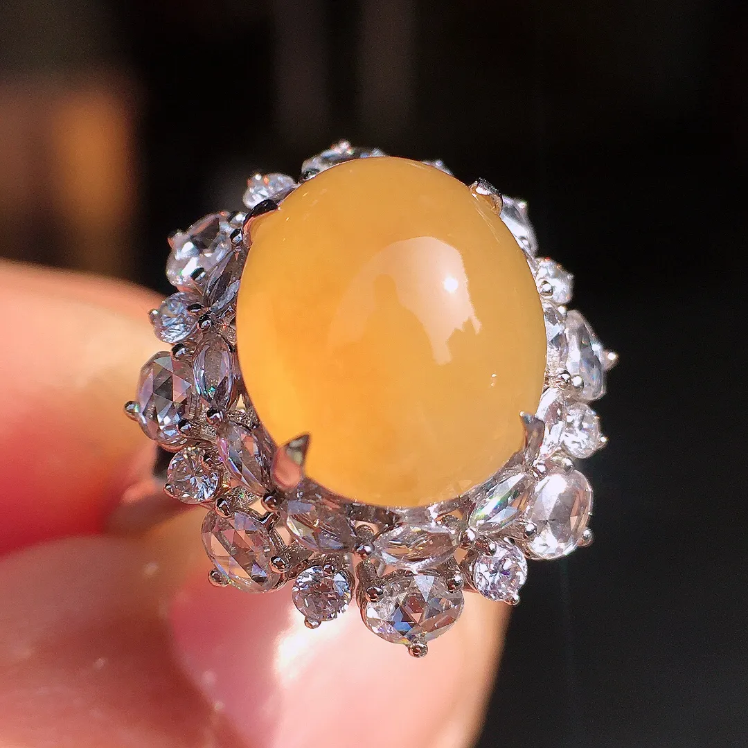 黄翡蛋面戒指，色泽均匀艳丽，玉质细腻，荧光感超
强，饱满圆润，尽显优雅气质，18k
金豪华镶嵌