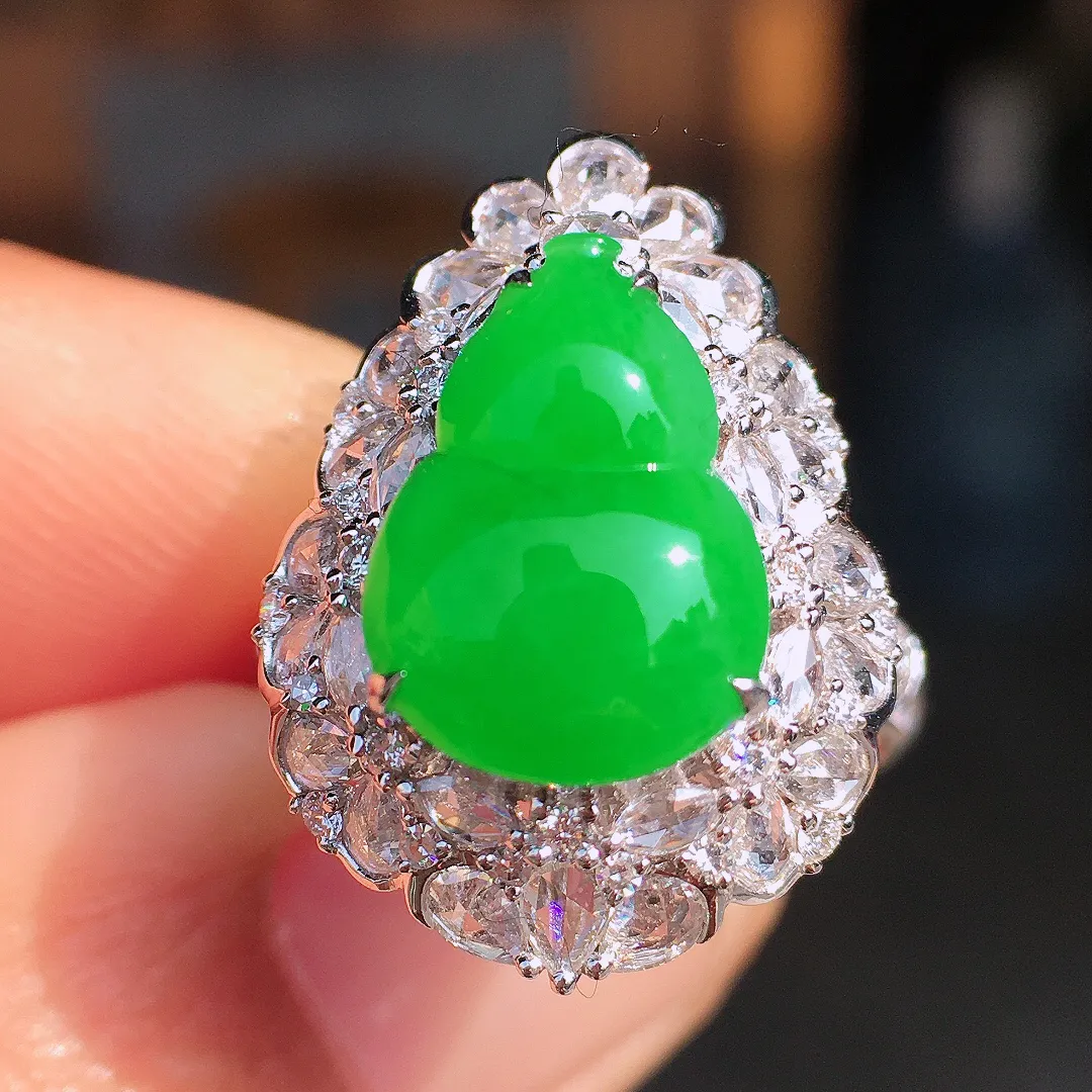 阳绿葫芦戒指，色泽均匀艳丽，玉质细腻，荧光感超
强，饱满圆润，尽显优雅气质，18k
金豪华镶嵌