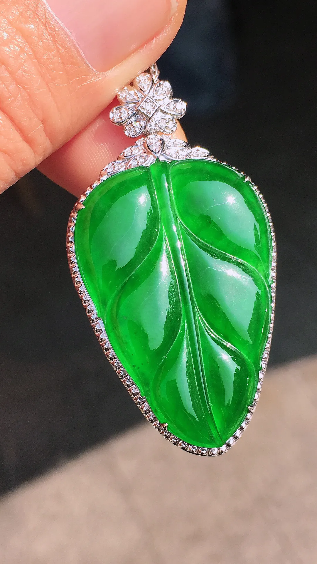 阳绿玉叶吊坠，色泽均匀艳丽，玉质细腻，荧光感超
强，饱满圆润，尽显优雅气质，18k
金豪华镶嵌