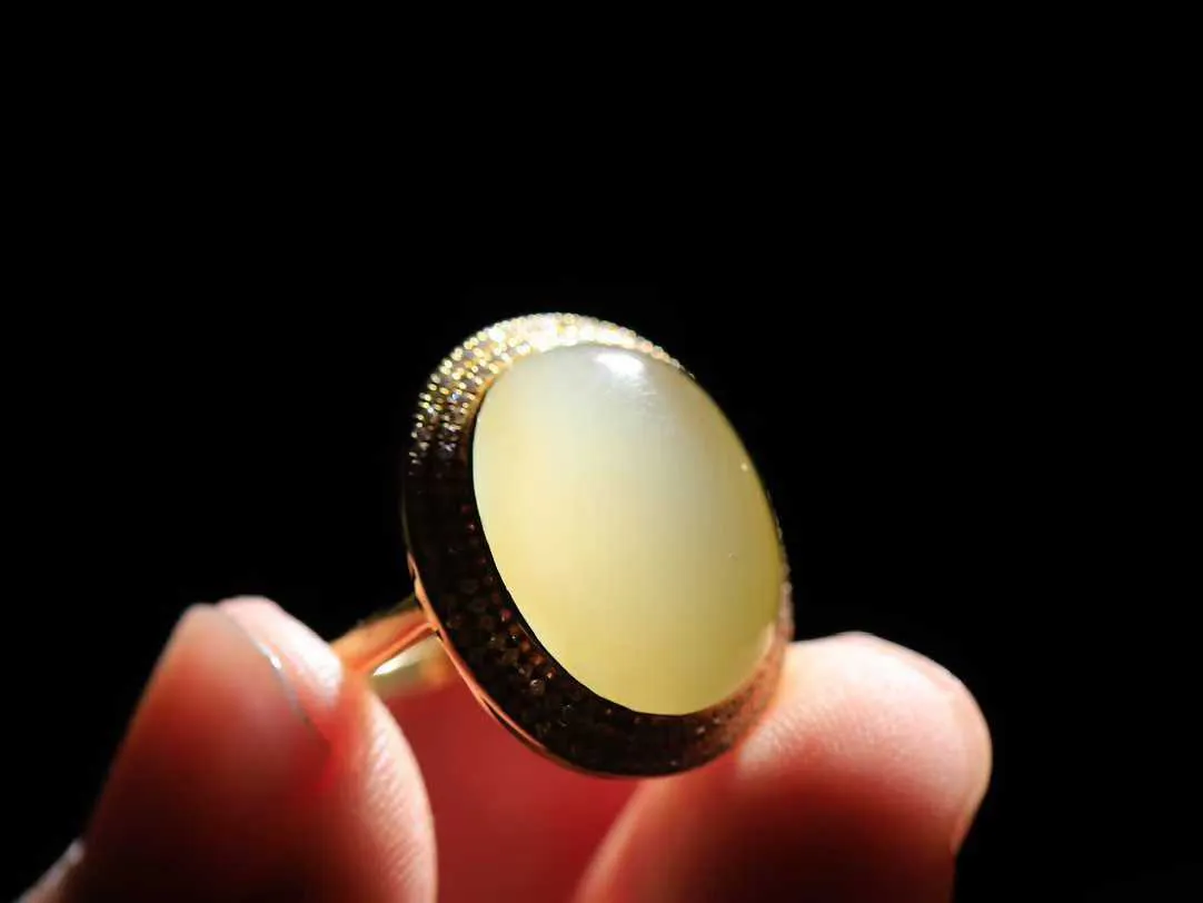 【金镶玉.戒指】

精品和田玉黄口猫眼18k金戒指 玉质细腻温润 油性十足 ，不论时光如何流转变化，这枚戒指始终闪耀着最初的光芒。精工镶嵌18K金 （保真金 可检测贵金属18K金） 重4.5克 内径16.8mm尺寸16.8-13.6mm 55142833T