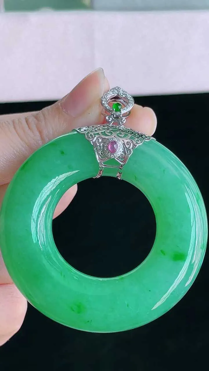 【翡翠名称】18K金镶钻冰阳绿平安环翡吊坠
【翡翠尺寸】裸石53.2/12.6mm
【翡翠描述】宝贝种老水足，玉质细腻，色泽靓丽，性价比高，佩戴效果好！
【其它赠送】权威证书/精美挂绳盒子/支持全国复检