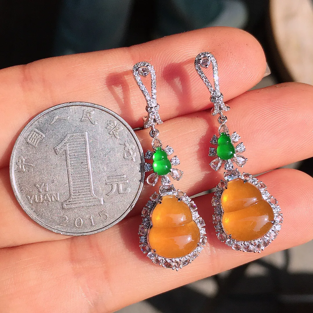 黄翡葫芦耳坠，色泽均匀艳丽，玉质细腻，荧光感超
强，饱满圆润，尽显优雅气质，18k
金豪华镶嵌